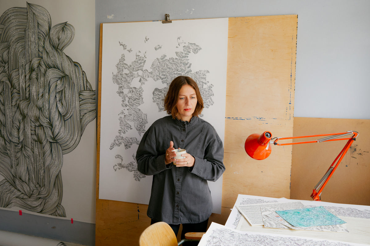 Die Künstlerin Bettina Krieg in ihrem Atelier umgeben von großen Arbeiten  