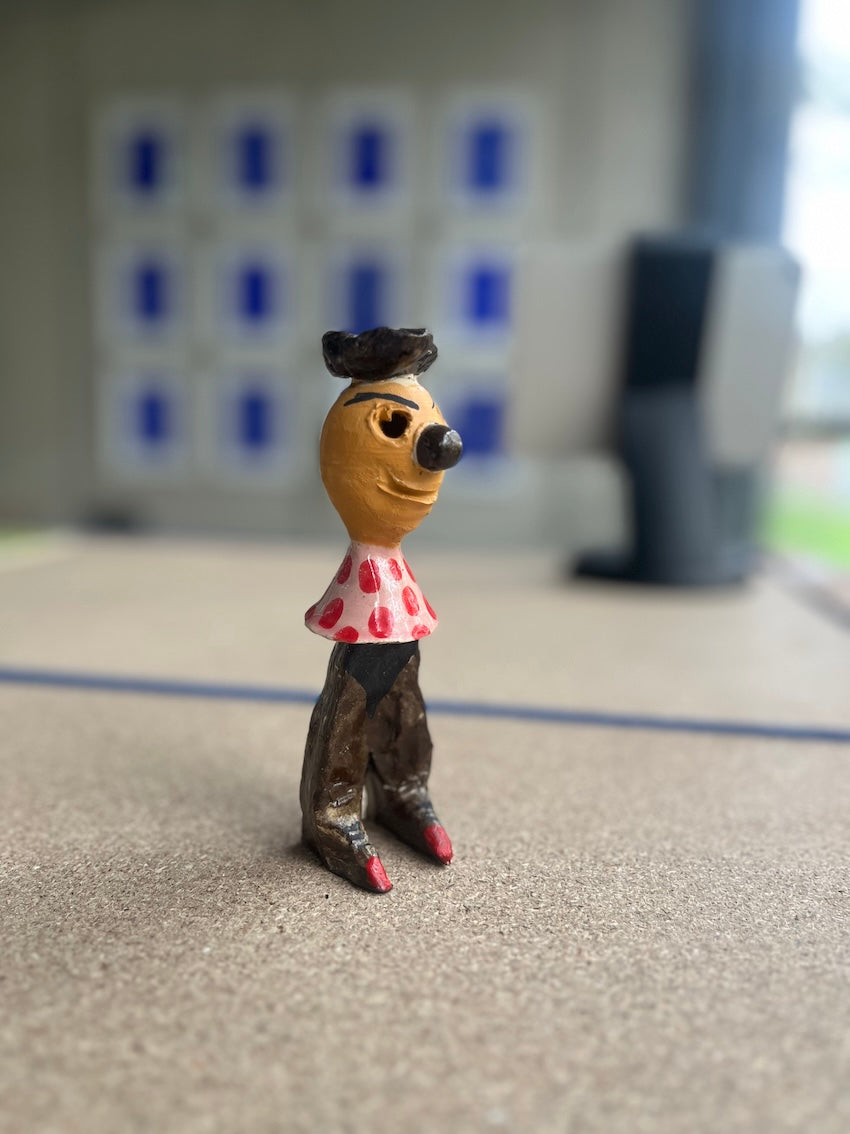 Kleinformatige Keramikskulptur „Salvador“ des Künstlerduos 44flavours. Es handelt sich um eine kleine Figur in mit kessem  Hütchen, rot gepunktetem Oberteil und brauner Hose.