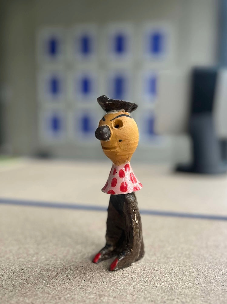 Kleinformatige Keramikskulptur „Salvador“ des Künstlerduos 44flavours. Es handelt sich um eine kleine Figur in mit kessem  Hütchen, rot gepunktetem Oberteil und brauner Hose.