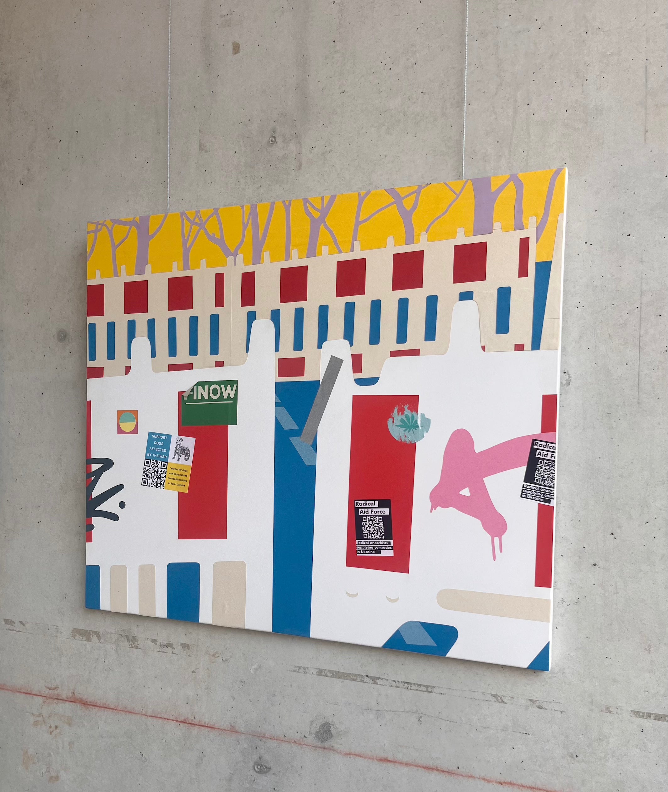 Vor einer Wand aus Sichtbeton hängt eine komplexe Collage aus Scherenschnitten. Im Vordergrund sind leicht geöffnete Baustellenabsperrungen zu erkennen, in der Mitte sieht man den Ausschnitt einer leeren Straße und hinten erneut Absperrungen vor Bäumen. 