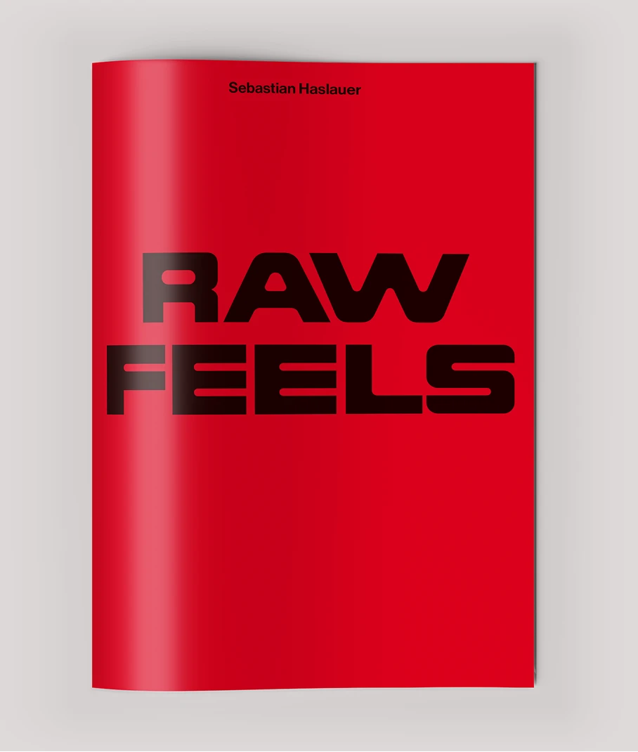 Vor einem neutralen Hintergrund sehen wir das Cover des Künstlerbuches „Raw Feels“ von Sebastian Haslauer. Das Cover ist knallrot und enthält nichts außer dem Namen Sebastian Haslauer und dem Titel „Raw Feels“ in schwarzer Schrift.