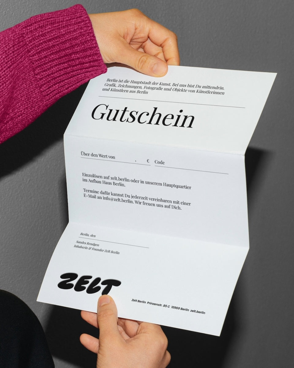 Zwei Hände entfalten einen Bogen Papier, darauf steht groß das Wort „Gutschein“ und unten das Logo „ZELT“